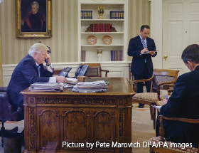 1月28日、大統領執務室でメルケル独首相と電話会談するトランプ米大統領