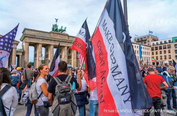 8月29日、ベルリンのブランデンブルク門の前で帝国旗を掲げる人々