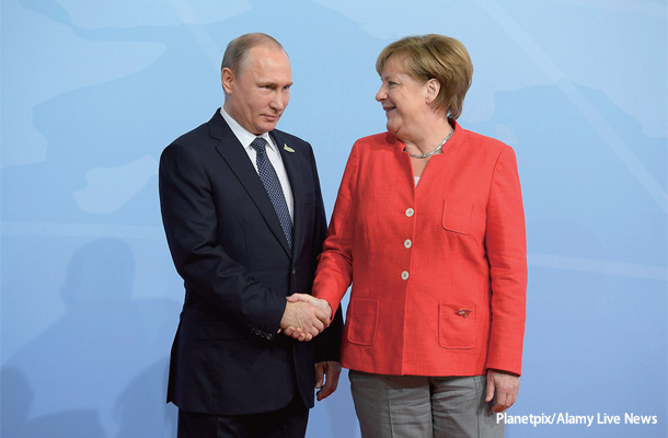 2017年7月7日、ハンブルクで開かれたG20で握手するプーチン大統領とメルケル前首相