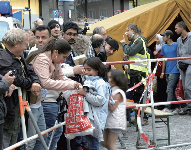 2015年にミュンヘン中央駅に到着したシリア難民たちと、迎えるミュンヘン市民（筆者撮影）